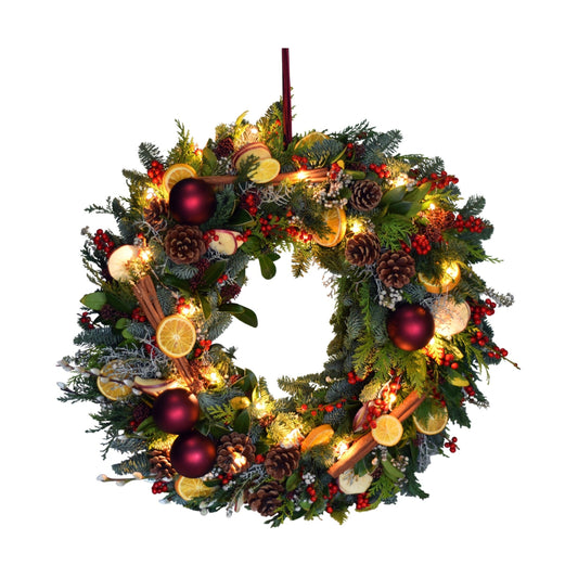 A festive Christmas door wreath adorned with orange slices, pinecones, stars, and Christmas lights, designed to be hung on a door.